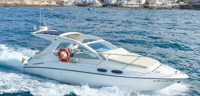 Champagne motorboat cruising with crew aboard